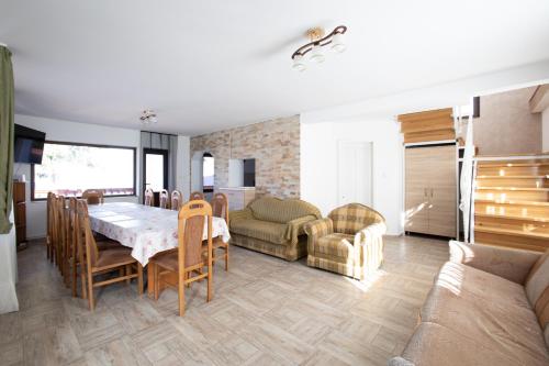 a kitchen and dining room with a table and chairs at CASUTA LANGA LAC in Colibiţa