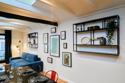 un salon avec un canapé bleu et une table dans l'établissement Renovated two-bedroom loft veranda, à Tourcoing