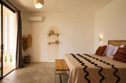 a bedroom with a large bed and a table at Kawga Hôtel in Ngaring