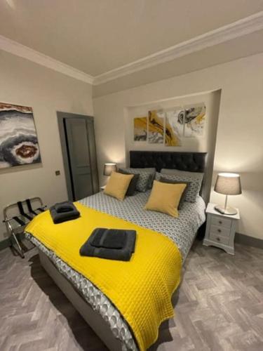 a bedroom with a large bed with a yellow blanket at Complete City Centre Comfort in Edinburgh