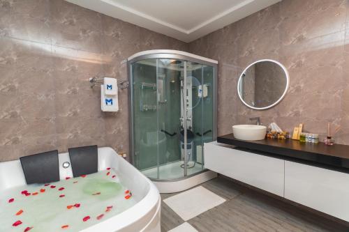 a bathroom with a shower and a toilet and a tub at Marlin All Inclusive Resort in Kasoa