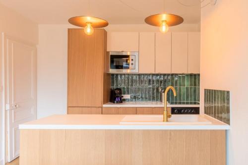 La cuisine est équipée d'un évier et d'un four micro-ondes. dans l'établissement 3 bedroom apartment on the Grand Place, à Lille