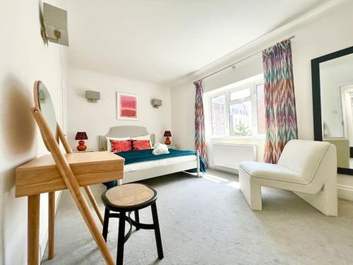um quarto com uma cama, uma cadeira e uma secretária em Mayfair - Split Level 2 Bed Apartment em Londres