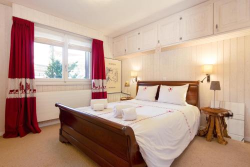 een slaapkamer met een groot bed met rode gordijnen bij Skirama 015 in Verbier