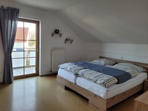 a bedroom with a bed and a large window at Rudis Ferienwohnung in Kirchham