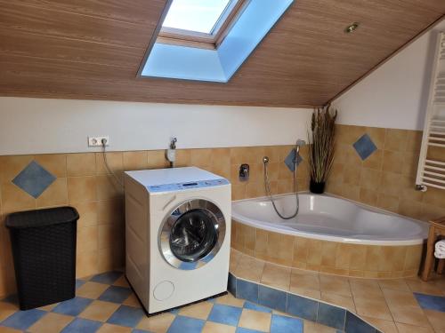a bathroom with a washing machine and a tub at Rudis Ferienwohnung in Kirchham