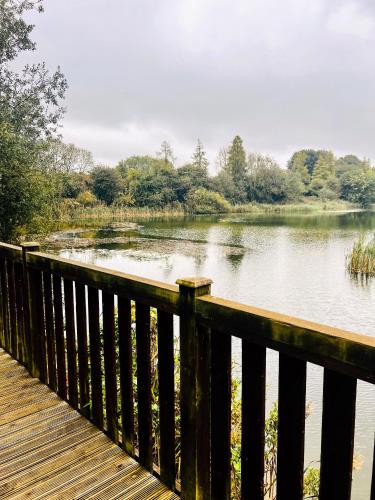 a wooden bridge over a body of water at 'Little Grebe' - Secluded Rustic Lodge - Fishermans delight. in York