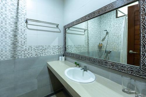 een badkamer met een wastafel en een grote spiegel bij Cove Raddeyapa in Canggu