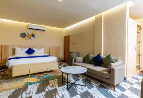 Marlin All Inclusive Resort في Kasoa: غرفة نوم بسرير واريكة وطاولة