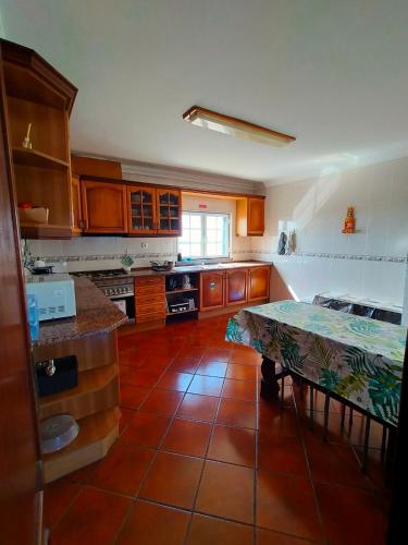 a kitchen with a table in the middle of it at I Ka Hale in Vila Nova de Milfontes