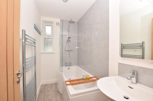 a white bathroom with a sink and a shower at Number 19 in Bude