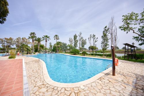 a large swimming pool in a park with trees at Glamping Costa Brava in Fortiá