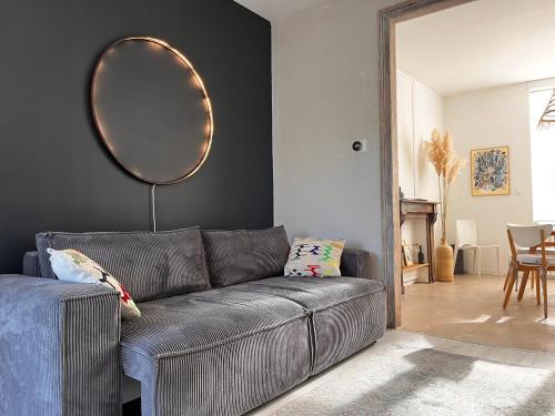 Sala de estar con sofá gris y espejo en La Baraque Calais Blériot 2, en Sangatte