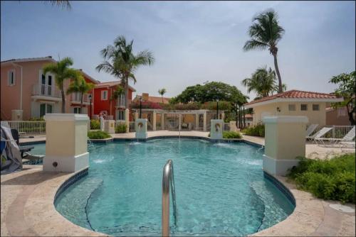 a swimming pool in a yard with palm trees at Luxury 3 Bedroom at El Conquistador in Fajardo