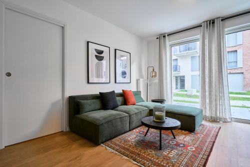 un salon avec un canapé vert et une table dans l'établissement Apartment in a new residence with parking, à Mouvaux