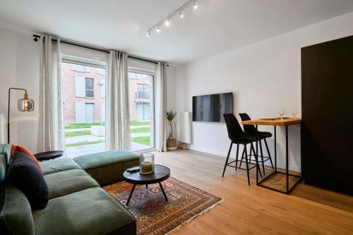 een woonkamer met een bank en een tafel bij Apartment in a new residence with parking in Mouvaux