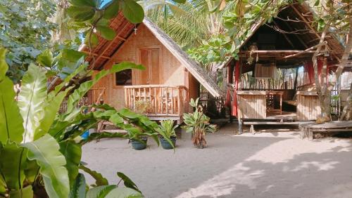 a wooden house with a porch and a balcony at Balai Ko Beach & Cottages in El Nido