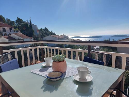 a table with two cups of coffee on a balcony at Apartments Zvonimir in Hvar