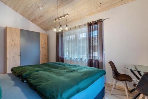 Un dormitorio con una cama verde y una mesa en Im Rosengarten 3, en Zell am Harmersbach