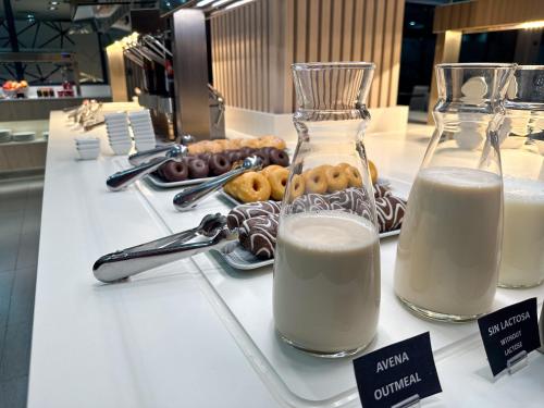 a counter with two glasses of milk and donuts at Turia Granada in Granada