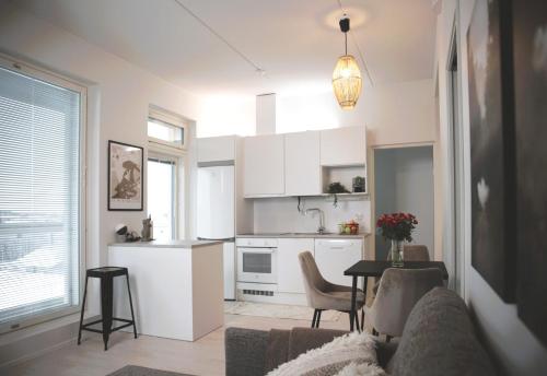 cocina y sala de estar con sofá y mesa en New 3-Bed Apartment & Free Garage parking & PS5 en Vantaa