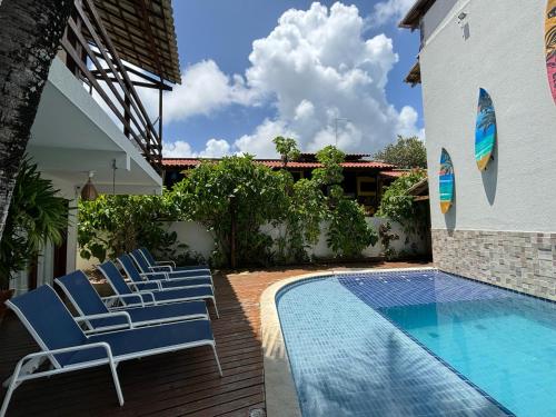 a group of chairs sitting next to a swimming pool at Pousada Waikiki Boutique in Pipa