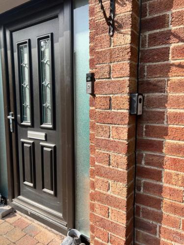 a black door on the side of a brick building at Macs Belfast Single bedroom in Belfast