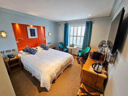 a bedroom with a bed and a table and chairs at King Sitric in Howth