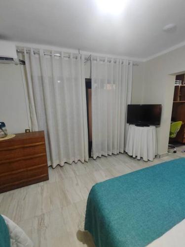 Schlafzimmer mit einem Bett und einem Flachbild-TV in der Unterkunft Alojamiento-frente al estadio 4 personas in Tarija