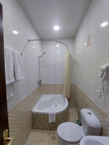 uma casa de banho com um WC e uma banheira em Hotel Shams Khiva em Khiva