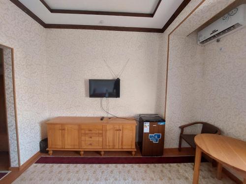 希瓦的住宿－Hotel Shams Khiva，客房设有电视和木制橱柜。