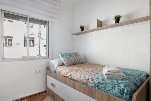 Habitación pequeña con cama y ventana en Apartamento Faro de Barbate, en Barbate