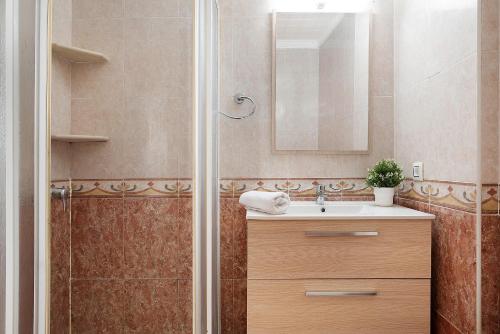 y baño con ducha, lavabo y espejo. en Apartamento Faro de Barbate, en Barbate