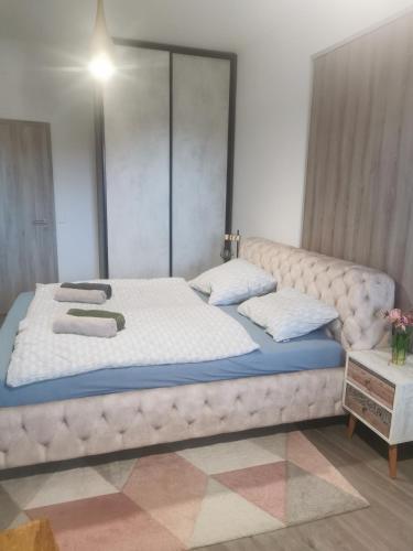 a bedroom with a large bed in a room at Beli Apartman Mélygarázzsal in Hévíz