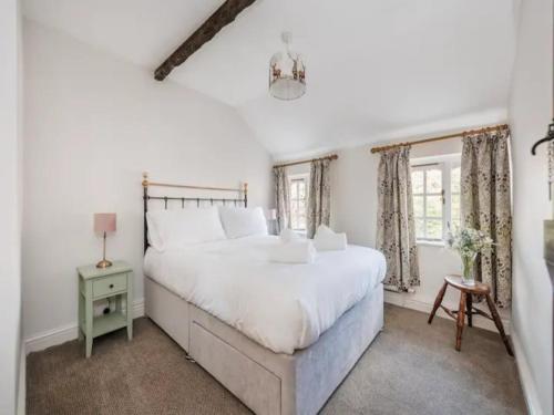 a white bedroom with a large bed and a window at Pass the Keys Shrewsbury Grade 2 Listed Black White Cottage in Shrewsbury