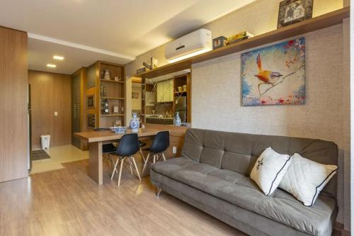 uma sala de estar com um sofá e uma cozinha em Apartamento Novo e Moderno em Gramado em Gramado
