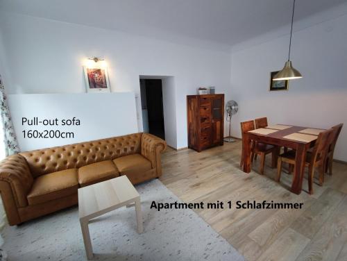 een woonkamer met een bank en een tafel bij Altstadtwohnungen "Grünberg 1D" & "Gmunden 3D mit Seeblick" im Zentrum von Gmunden in Gmunden