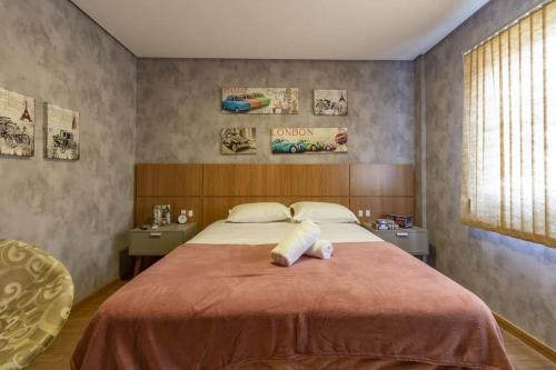 um quarto com uma cama grande e um cobertor vermelho em Apartamento Novo e Moderno em Gramado em Gramado