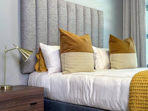 a bed with several pillows on it in a room at Seed @Colette in Pretoria