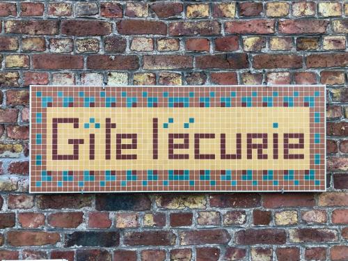 a sign on a brick wall that reads the future at Gîte l'Ecurie in Jodoigne