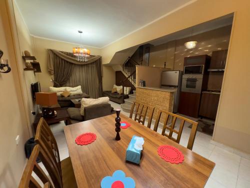 a kitchen and living room with a wooden table and chairs at Cozy Townhouse, with back yard (98) in Sheikh Zayed