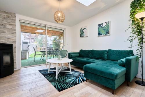 a living room with a green couch and a table at 3 bedroom house with garden near St Maur tram in Marcq-en-Baroeul