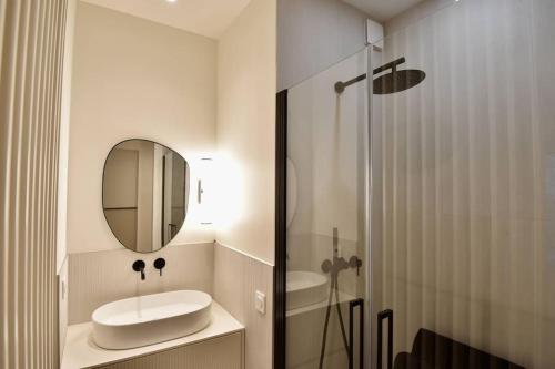 uma casa de banho com um lavatório, um espelho e um chuveiro em Nice Signature Mont Alban em Nice