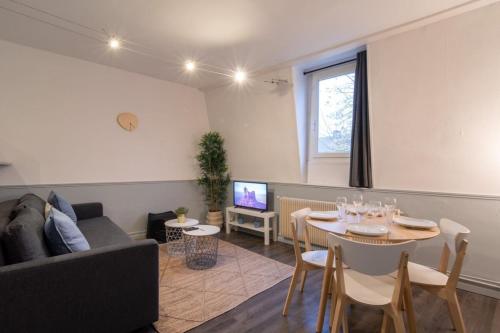 un salon avec un canapé et une table dans l'établissement Apartment near the train station ouigo TGV, à Tourcoing