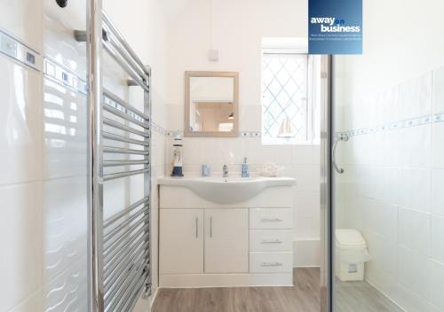 a white bathroom with a sink and a shower at St Martins Square Chichester in Chichester
