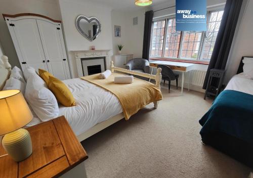 a bedroom with a bed and a table and a desk at St Martins Square Chichester in Chichester