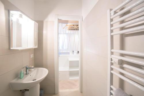 a white bathroom with a sink and a mirror at Ca Viola e Tobia by Venicevillas in Venice