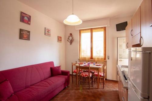 ein Wohnzimmer mit einem lila Sofa und einem Tisch in der Unterkunft Appartamento PE in Follonica