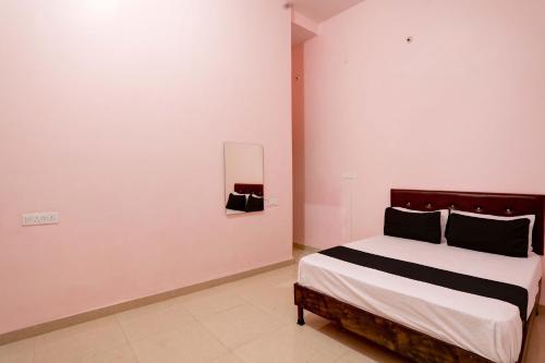 een slaapkamer met een bed in een witte kamer bij Hotel O Blue Moon in Bhilai