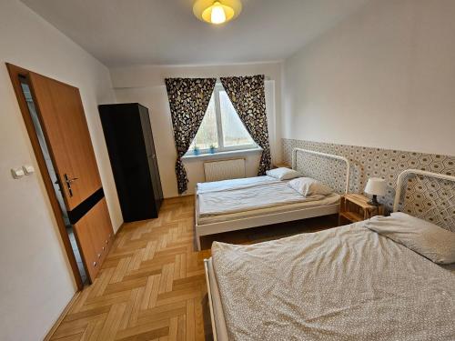 a room with two beds and a window at Green Kabaty Apartment 2 in Warsaw